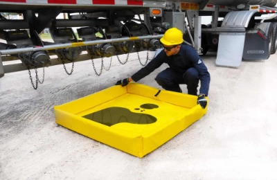 worker removing a portable mini spill berm