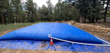 Collapsible pillow tank being filled for temporary water storage