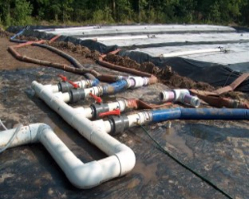 Rows of geotextile dewatering tubes on a lined pad for a dredging project in Texas