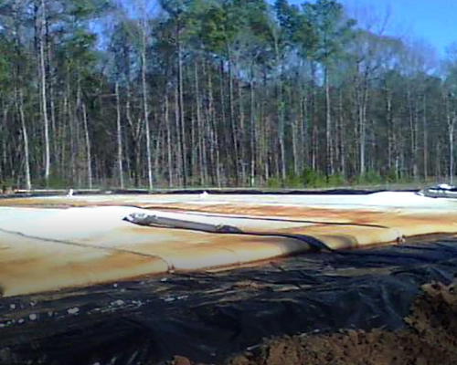Dewatering tubes staged on a lined pad at a coal station in South Carolina
