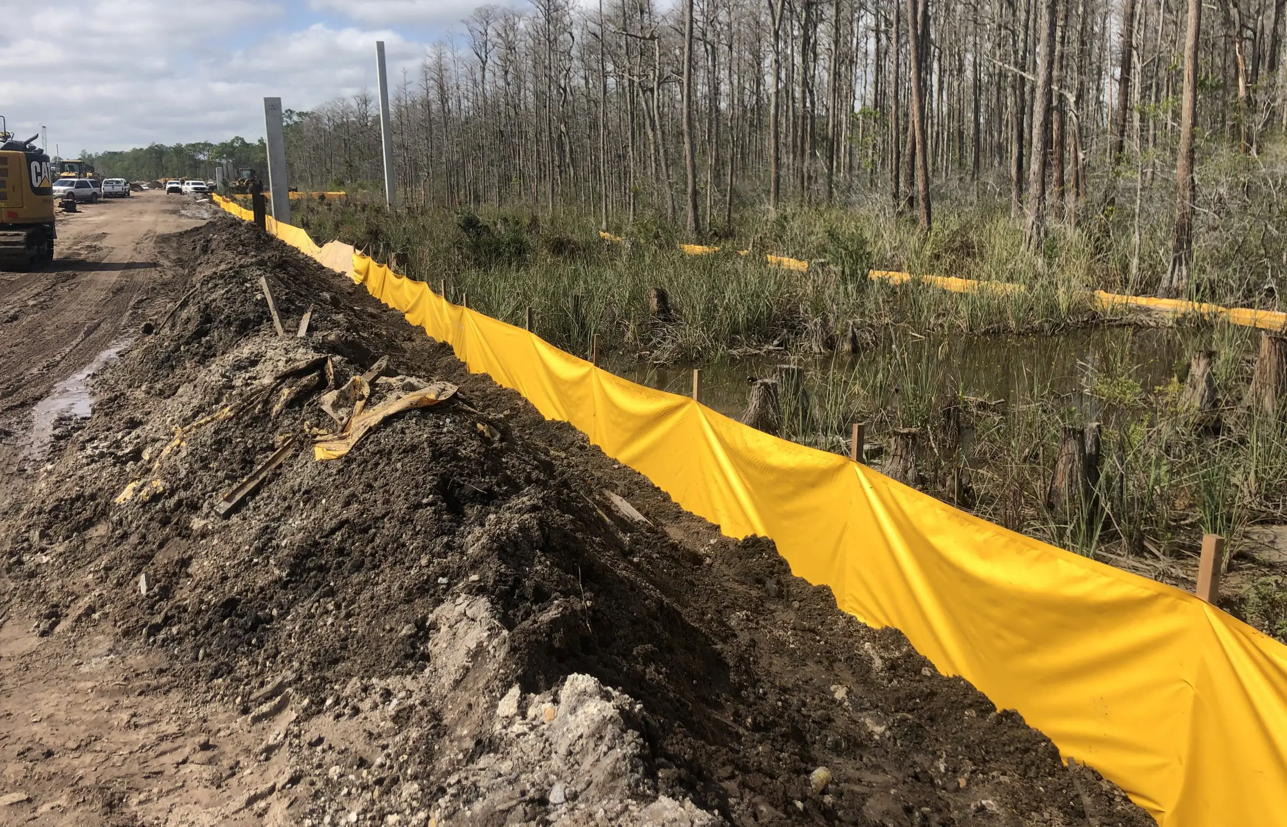 Yellow staked sediment barrier installed along wetland construction site