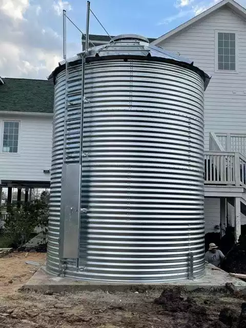 Corrugated water tank with a roof and ladder
