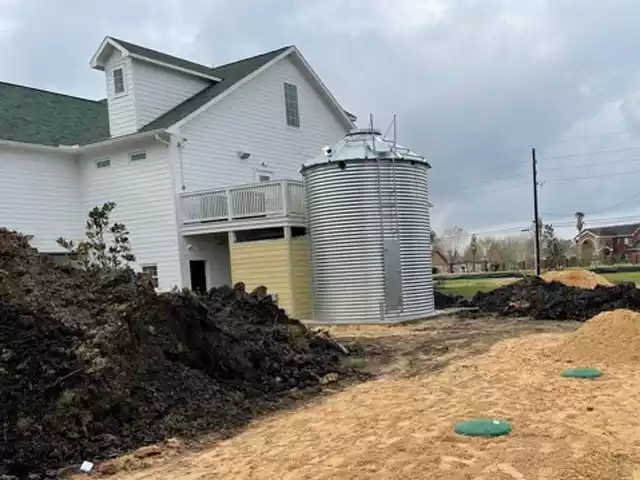 Corrugated Tank with a roof and ladder installed in a back yard